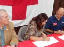 Red Cross Executive Lee Vanessa Feliciano signs the MoU between the Red Cross Puerto Rico Chapter and the ARRL Puerto Rico Section, as ARRL SM Oscar Resto, KP4RF (right) and Red Cross Regional Disaster Officer Ángel Jiménez look on.
